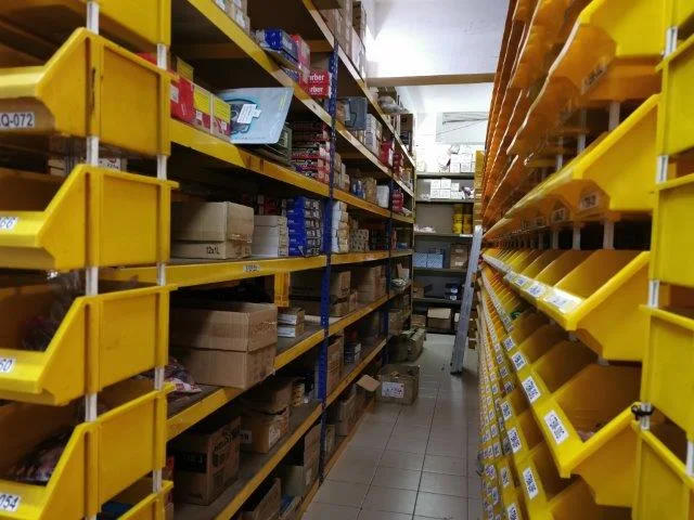 Warehouse aisle lined with yellow storage bins and shelved cartons